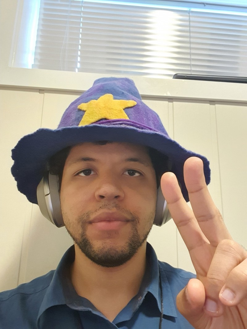 Photo of Kevin Kaland (wizonesolutions) wearing his wizard hat giving a peace sign.