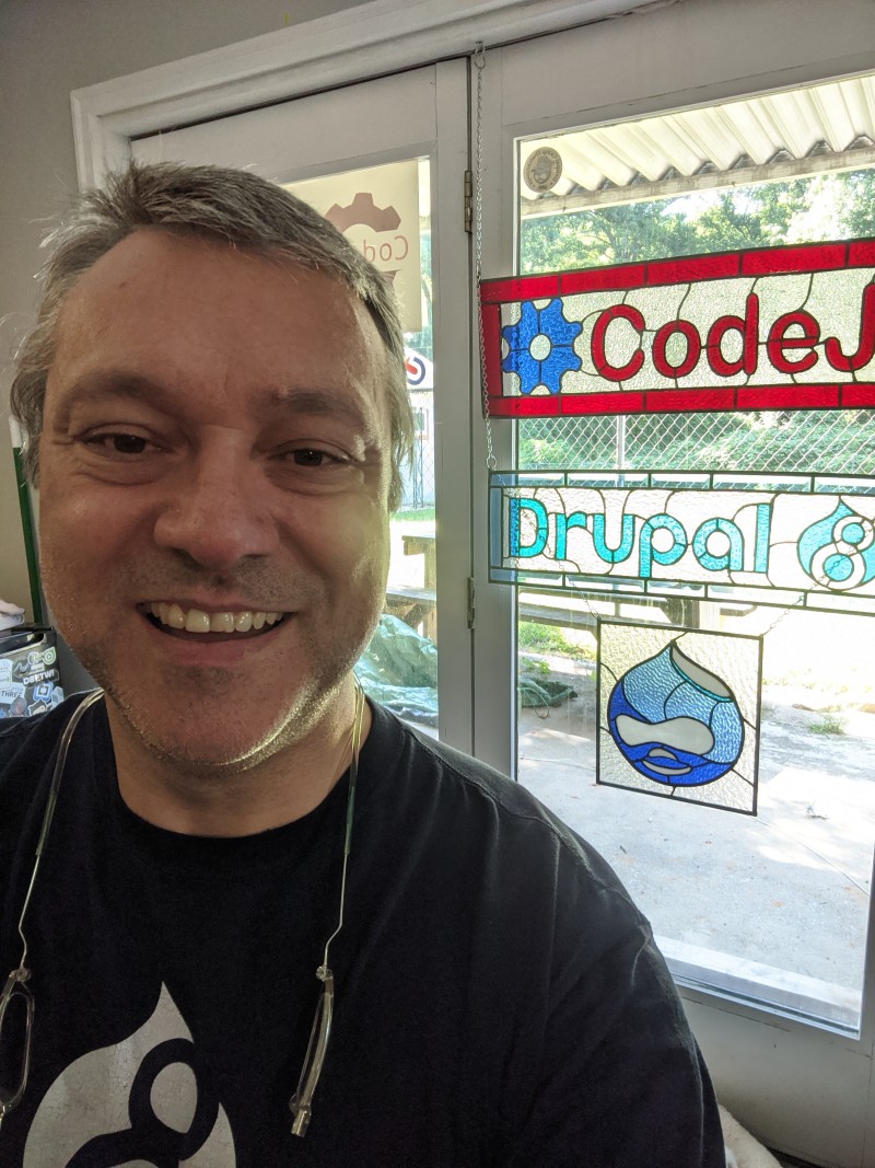 Drupal selfie with Drupal logos in background
