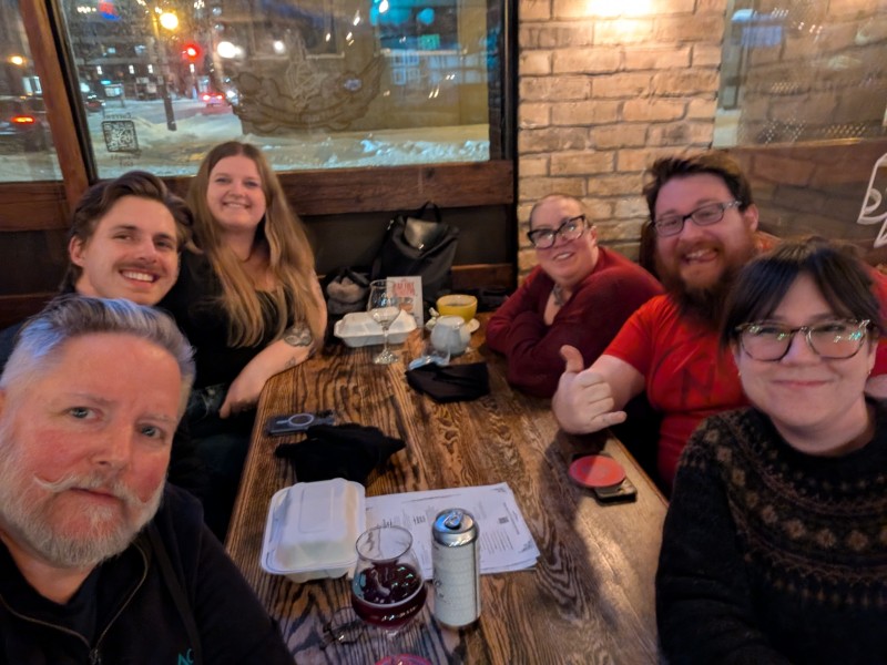 Six Drupalists seated around a table, smiling