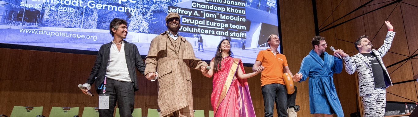 People dressed up in costumes, on stage after singing and dancing in the DrupalCon prenote
