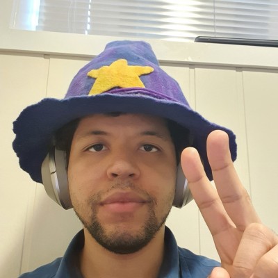 Photo of Kevin Kaland (wizonesolutions) wearing his wizard hat giving a peace sign.