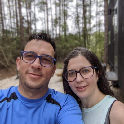 Carlos and Me with a background of trees and a cabin