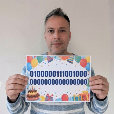 Photo of a person holding a big birthday card with binary numbers