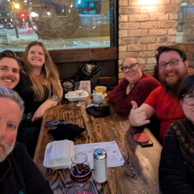 Six Drupalists seated around a table, smiling